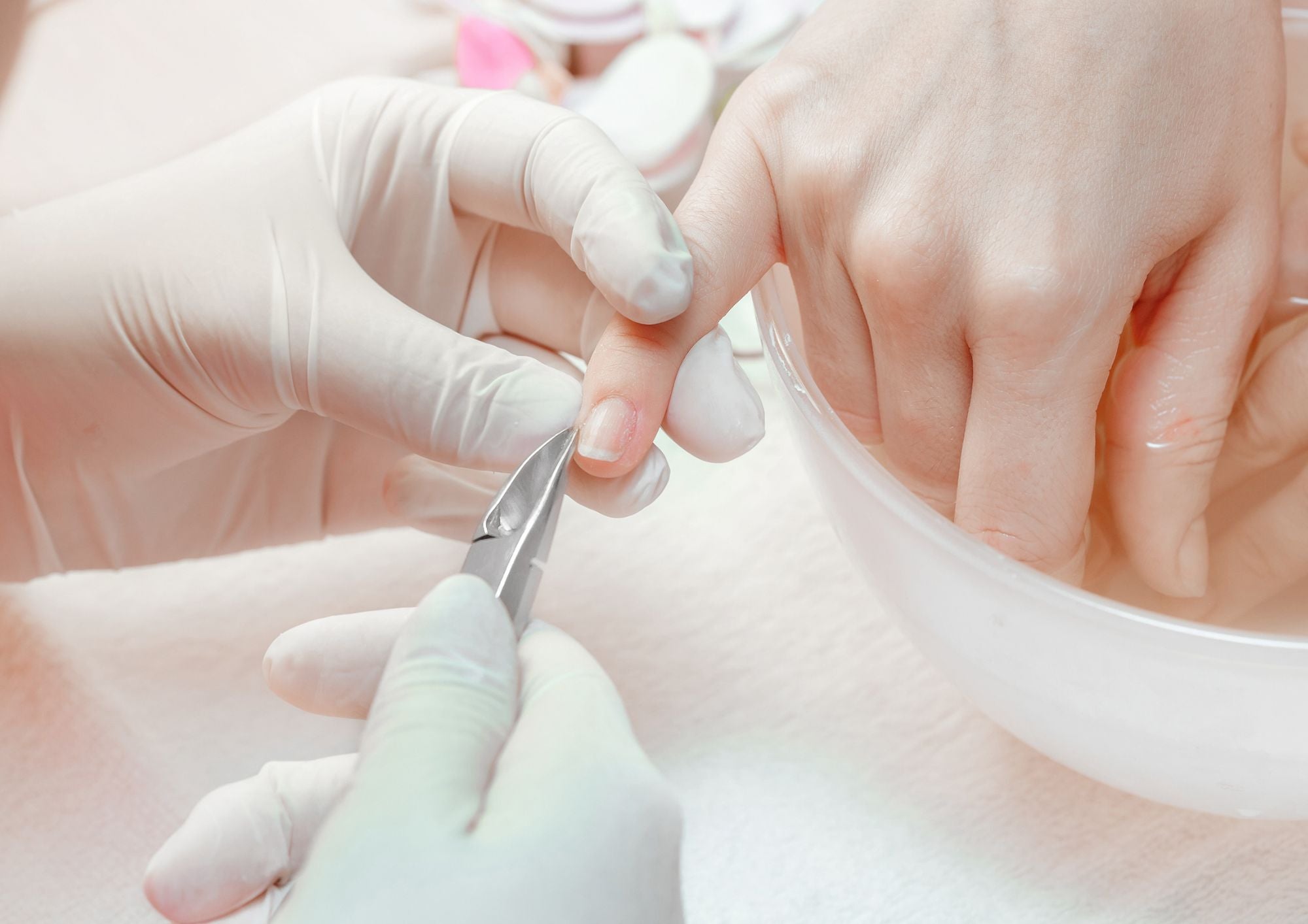 a manicure being performed on a client, cleaning and shaping the nail
